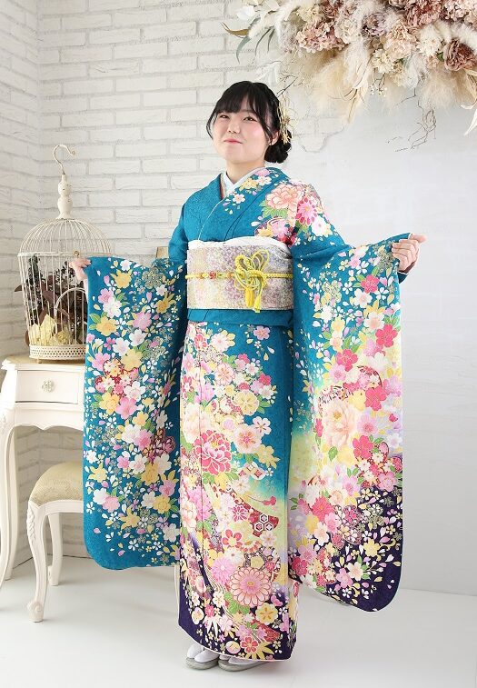 熨斗目柄の青緑色の振袖を着た女性